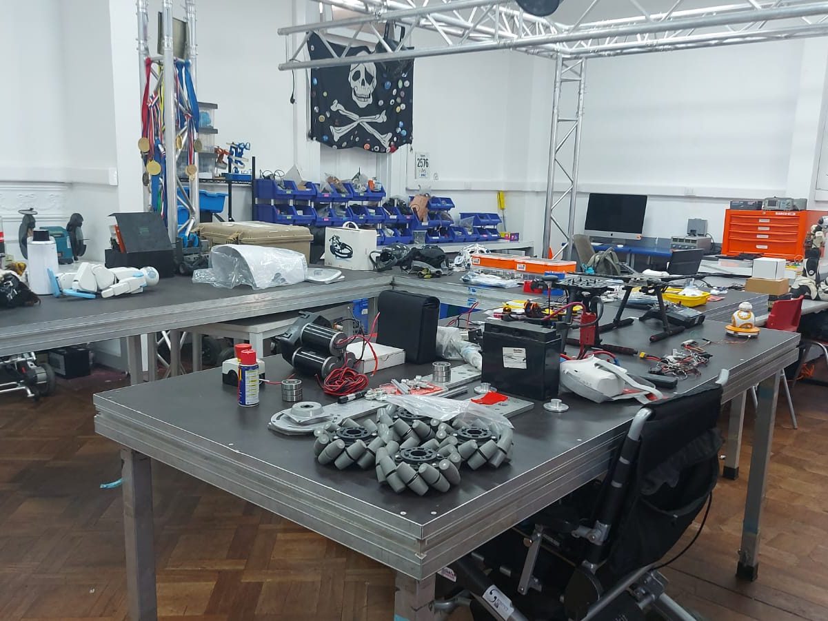 Taller con mesas de trabajo, carcazas de robot e instrumentos para ambientar un evento