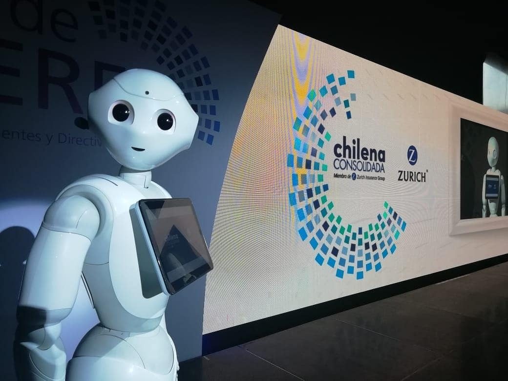 El robot Pepper haciendo de anfitrión junto a la pantalla LED de un evento corporativo
