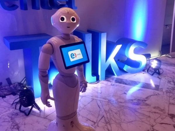 El robot Pepper ante las letras corpóreas iluminadas de un lanzamiento de marca