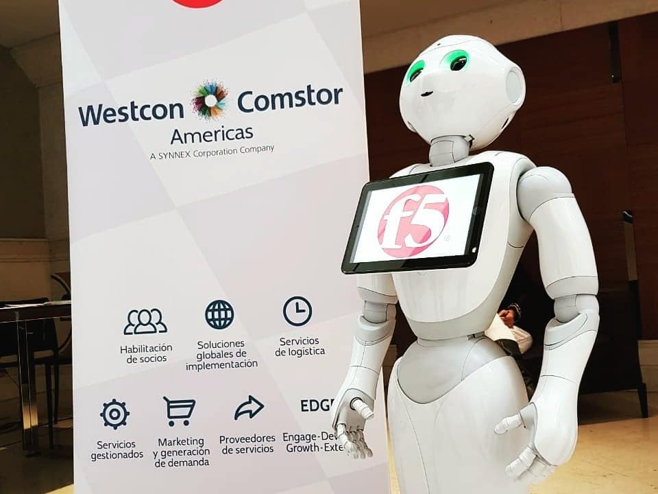 El robot Pepper junto al pendón de un cliente en una feria de empresas