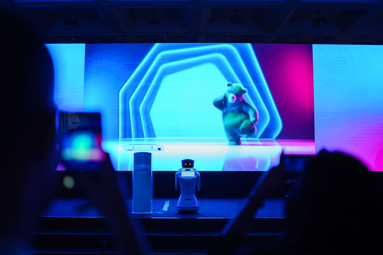 El público graba con el móvil al Robot Eva en el escenario de un evento