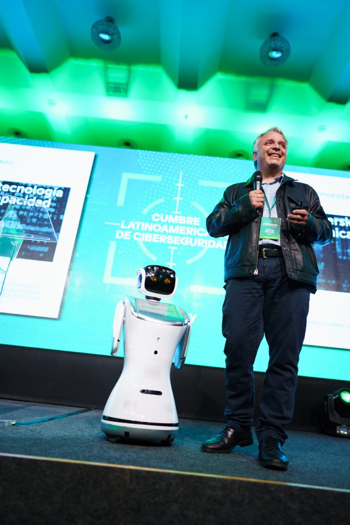 Robot Eva acompañando a un expositor en el escenario de un congreso