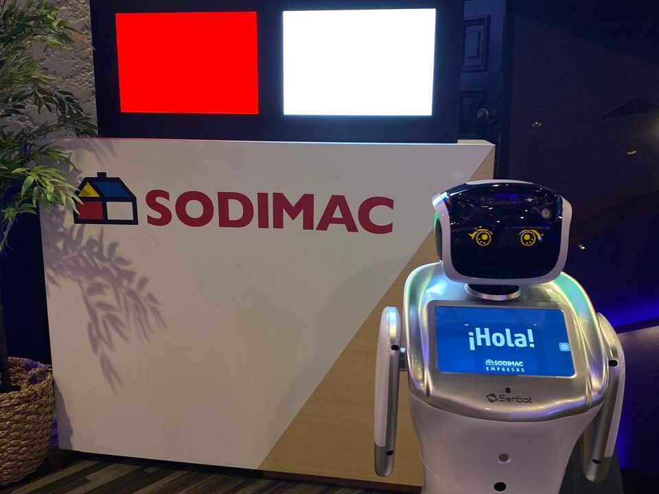 Robot Eva saludando con «¡Hola!» en su pantalla desde el estand de un evento de empresa