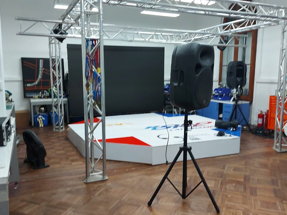 Estructura de truss de aluminio montada sobre una tarima, con pantalla y altavoz